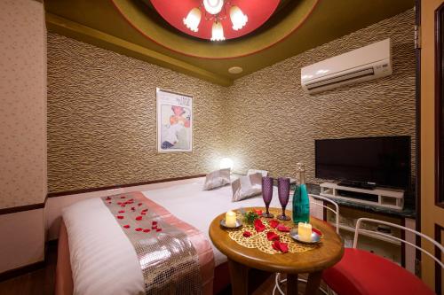 a hotel room with a bed and a table with candles at ホテルシェヌーAdult Only in Tokyo