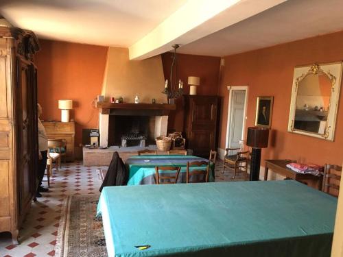 a living room with two tables and a fireplace at Grande Gte Du Chteau Des Moriers Fleurie in Fleurie