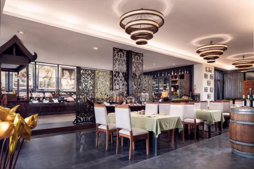 een restaurant met een tafel en stoelen en een bar bij Lynnaya Urban River Resort in Siem Reap