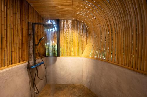 a shower in a room with a bamboo wall at Bamboo Zanzibar in Jambiani