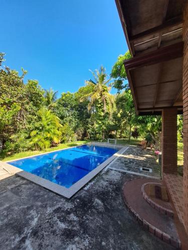 an image of a swimming pool in the backyard of a house at Dambullawatha Bungalow Garden Villa in Hikkaduwa
