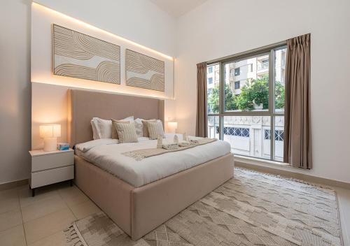 una camera da letto con un letto grande e una grande finestra di Luxurious 2-bedroom Apartment in Downtown with Burj Khalifa View a Dubai