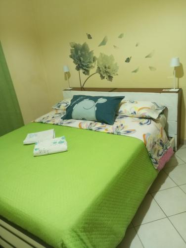 a bedroom with a bed with a green comforter at La Corte dei Morra in Venafro