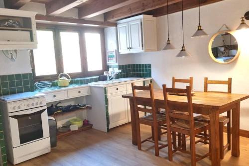 une cuisine avec une table en bois et une table et des chaises dans l'établissement Au fil de l'eau - Nature, à Saint-Floret