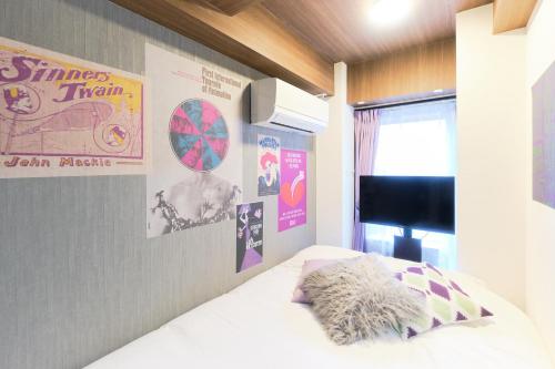 a bedroom with a bed and posters on the wall at Marine Cove Hatsudai by Tranova in Tokyo