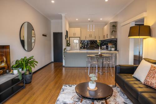 a living room and kitchen with a couch and a table at 2 bedroom Apartment in Ashfield, 200m to train station,Free Parking in Sydney