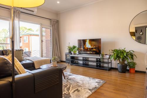 a living room with a couch and a flat screen tv at 2 bedroom Apartment in Ashfield, 200m to train station,Free Parking in Sydney