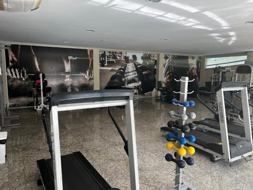 a gym with dumbbells and a wall with pictures at Águas da Serra in Rio Quente