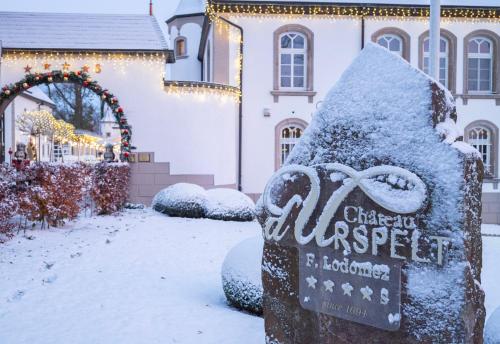 a snow covered sign in front of a house at Chateau d'Urspelt in Urspelt