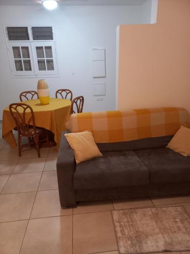 a living room with a couch and a table at Logement du soleil in Les Abymes