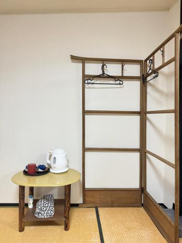 a table and a shelf with a toaster on it at Ikoi-no-Ie Guesthouse in Kyoto