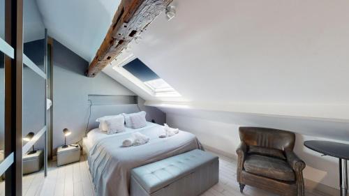 a attic bedroom with a bed and a chair at Bluestay 201 - Superb apartment in Paris in Paris
