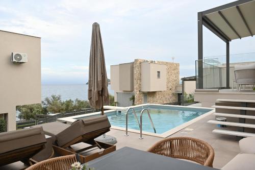 カヴァラにあるVilla Petraのスイミングプールとパティオ付きのヴィラ