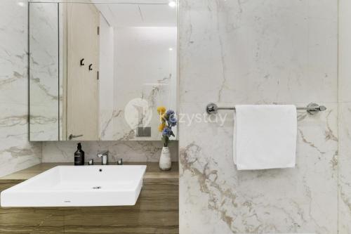 a white bathroom with a sink and a mirror at Inara by Kozystay - Cilandak in Jakarta