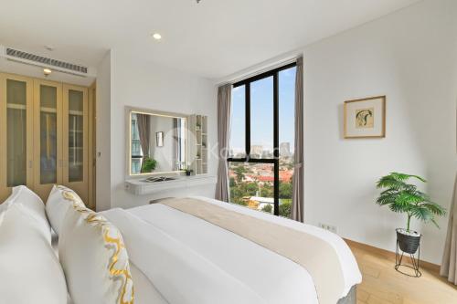 a white living room with a white couch and a window at Inara by Kozystay - Cilandak in Jakarta