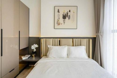 a bedroom with a large white bed and a table at Bống Homestay-Luxury Apartment-2PN in Long Bình