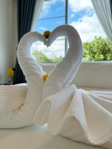 a towel shaped like a heart sitting on a bed at Garden House Rice Field and Mountain View in Luang Prabang