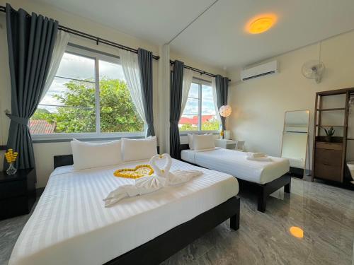 a bedroom with two beds and a large window at Garden House Rice Field and Mountain View in Luang Prabang