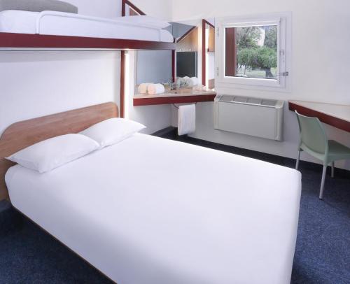 een slaapkamer met 2 stapelbedden, een bureau en een raam bij SUN1 Foreshore Cape Town in Kaapstad