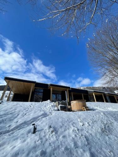 a building in the snow with a pile of snow at Vila Nura in Teşila