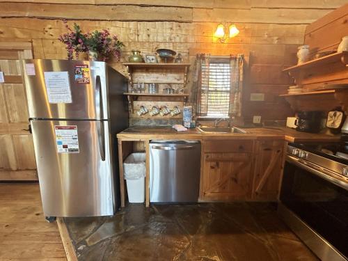 a kitchen with a stainless steel refrigerator and wooden cabinets at Honeymoon View #2 in Little Cove