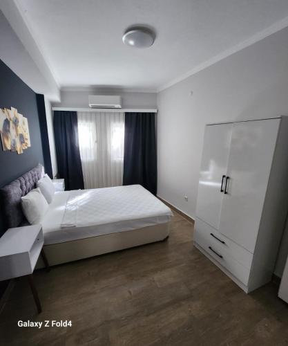 a bedroom with a white bed and a white cabinet at Loca Centre Suites in Bodrum City