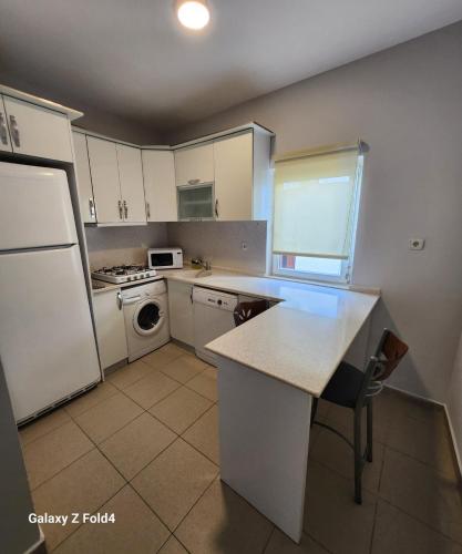 a kitchen with white cabinets and a white refrigerator at Loca Centre Suites in Bodrum City