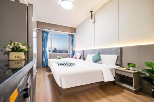 a hotel room with two beds and a window at Xi'an Yongning Apartment Hotel in Xi'an
