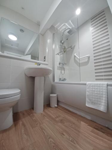 a bathroom with a sink and a shower and a toilet at The Osborne Apartments in Torquay