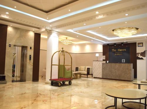 a lobby with a luggage cart in a room with tables at Hotel The Haven - Centrally Heated and Air Conditioned in Kargil