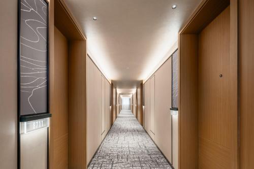 a corridor of a hotel hallway with a tile hallway at Atour Hotel Chongqing Jiangbei Airport Huanshan Park in Chongqing