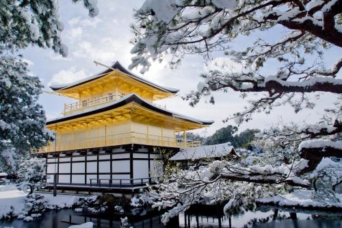 a yellow building in the snow with trees at MIMARU Kyoto Shinmachi Sanjo in Kyoto