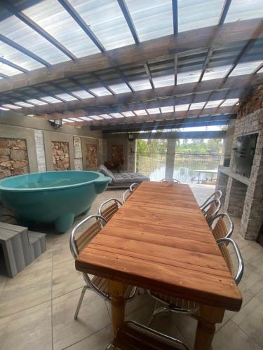 a large room with a wooden table and a bath tub at Out of Africa on Vaal in Parys