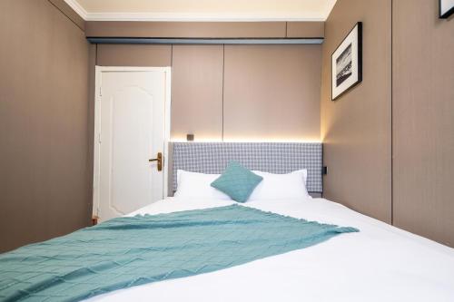 a bedroom with a large bed with a blue blanket at Xi'an Yongning Apartment Hotel in Xi'an