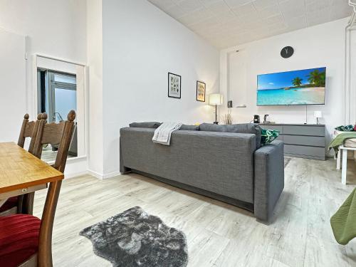 a living room with a couch and a table at 2 Zimmer Apartment für 6 P, 15 min zum Flughafen in Sirnau