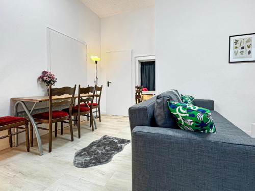 a living room with a blue couch and a table at 2 Zimmer Apartment für 6 P, 15 min zum Flughafen in Sirnau