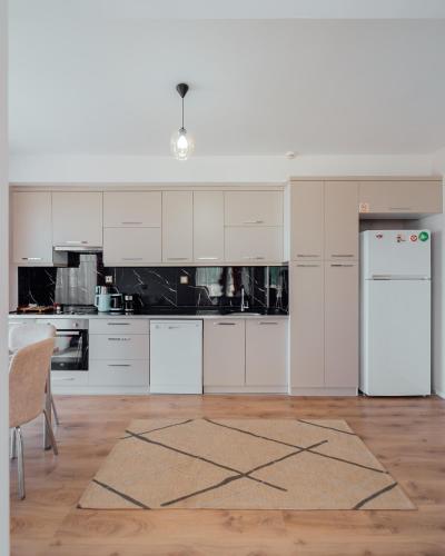 a kitchen with white cabinets and a white refrigerator at Fortunella Suites in Finike