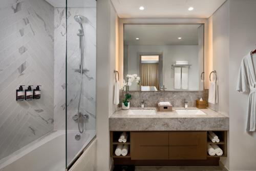 a bathroom with a sink and a shower at Millennium Residences Saadiyat Island in Ḩayl