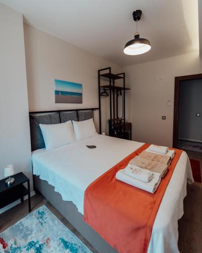 a bedroom with a large white bed with an orange blanket at Fortunella Suites in Finike