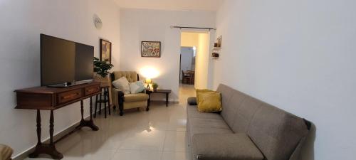 Una sala de estar con un sofá y un televisor de pantalla plana. en Red Door Valletta, en La Valeta