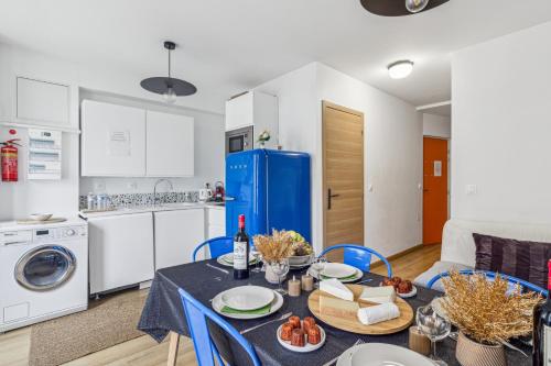 Il comprend une cuisine et une salle à manger avec une table et un réfrigérateur bleu. dans l'établissement Lavie Maison large comfy flat, à Bordeaux