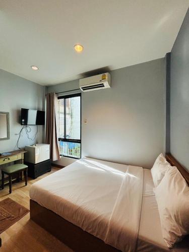 a bedroom with a white bed and a window at The LODGE BKK Hostel in Bangkok