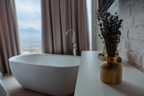 a bathroom with a white tub and a vase with flowers at Shakaryan Rancho&Restaurant in Dsegh