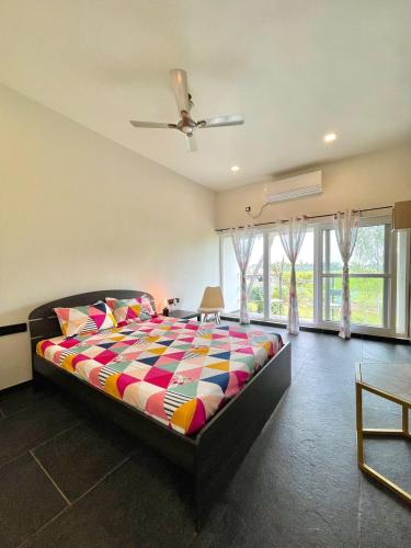 a bedroom with a bed with a colorful comforter at Six Boutique Collection in Mannārgudi