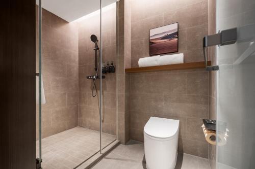 a bathroom with a shower stall and a toilet at Atour Hotel Chongqing Jiangbei Airport Huanshan Park in Chongqing