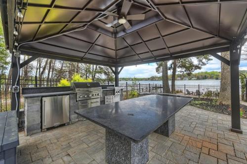 an outdoor kitchen with a table and a grill at Laid Back Lake Life by AvantStay Waterfront View in Mooresville
