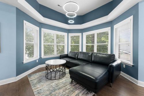 a living room with blue walls and a black leather couch at Laid Back Lake Life by AvantStay Waterfront View in Mooresville