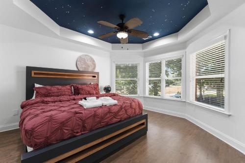 a bedroom with a red bed and a ceiling fan at Laid Back Lake Life by AvantStay Waterfront View in Mooresville