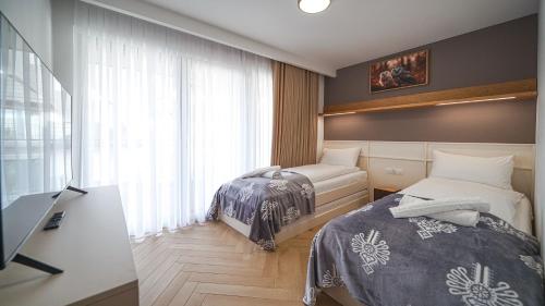 ein Schlafzimmer mit zwei Betten und einem Fenster in der Unterkunft Resorts P Białka Tatrzańska z sauną, Sun & Snow in Białka Tatrzańska