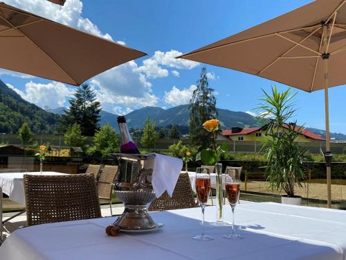 a table with wine glasses and a bottle of wine at Sporthotel Royer in Schladming